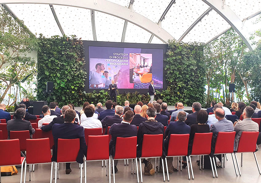 Convention aziendale, palco allestito con piante da interni e uno schermo per la presentazione in power point