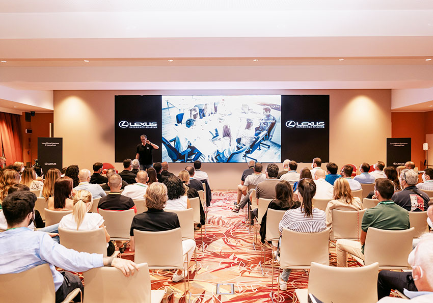 Convention Lexus, platea di spalle gurda la presentazione aziendale sullo schermo al centro del palco